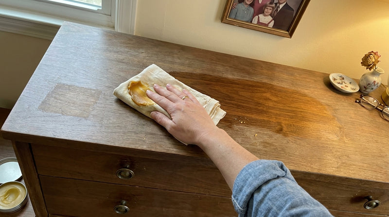 POV applying balm to vintage dresser